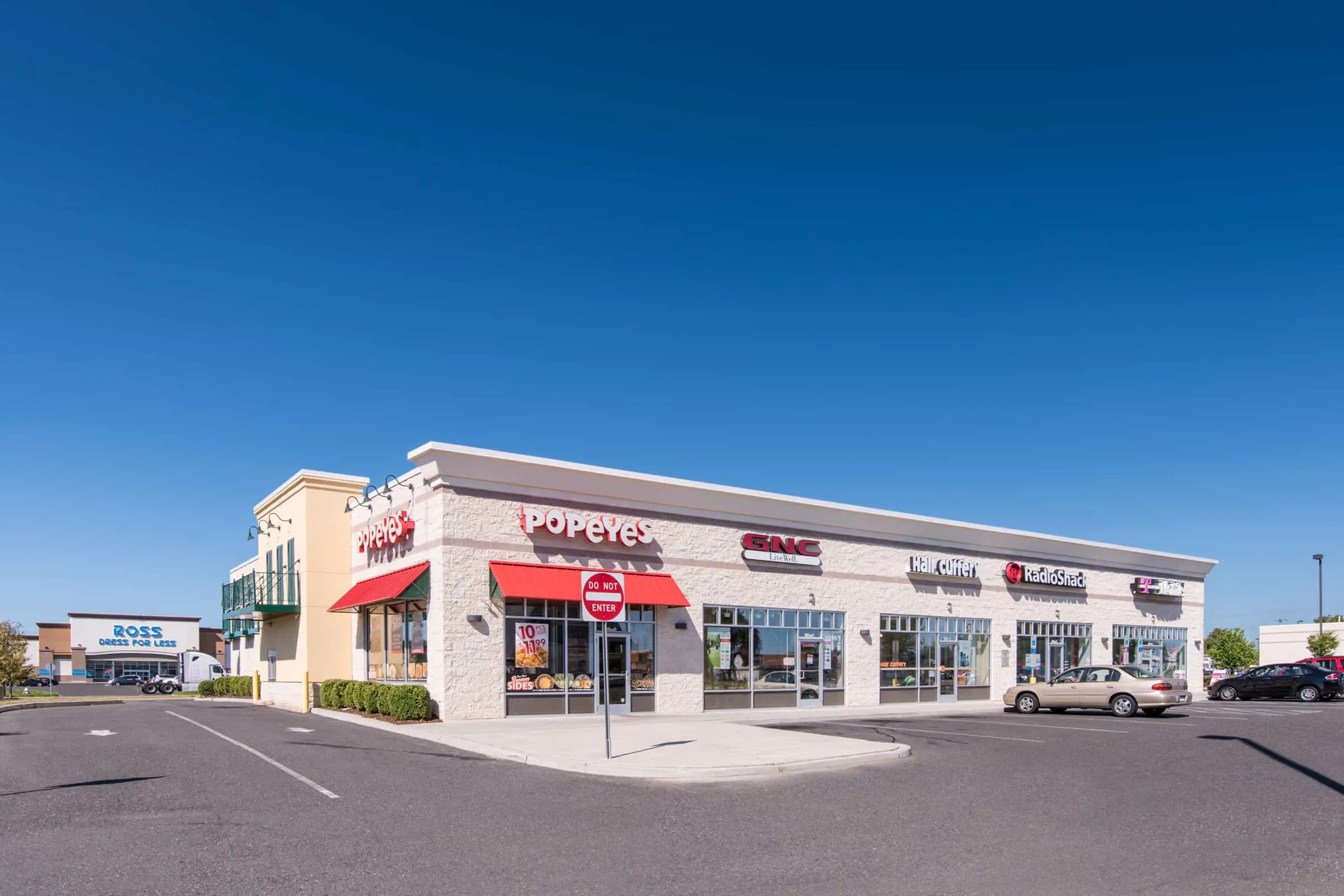 Strip mall with Popeyes and parking lot
