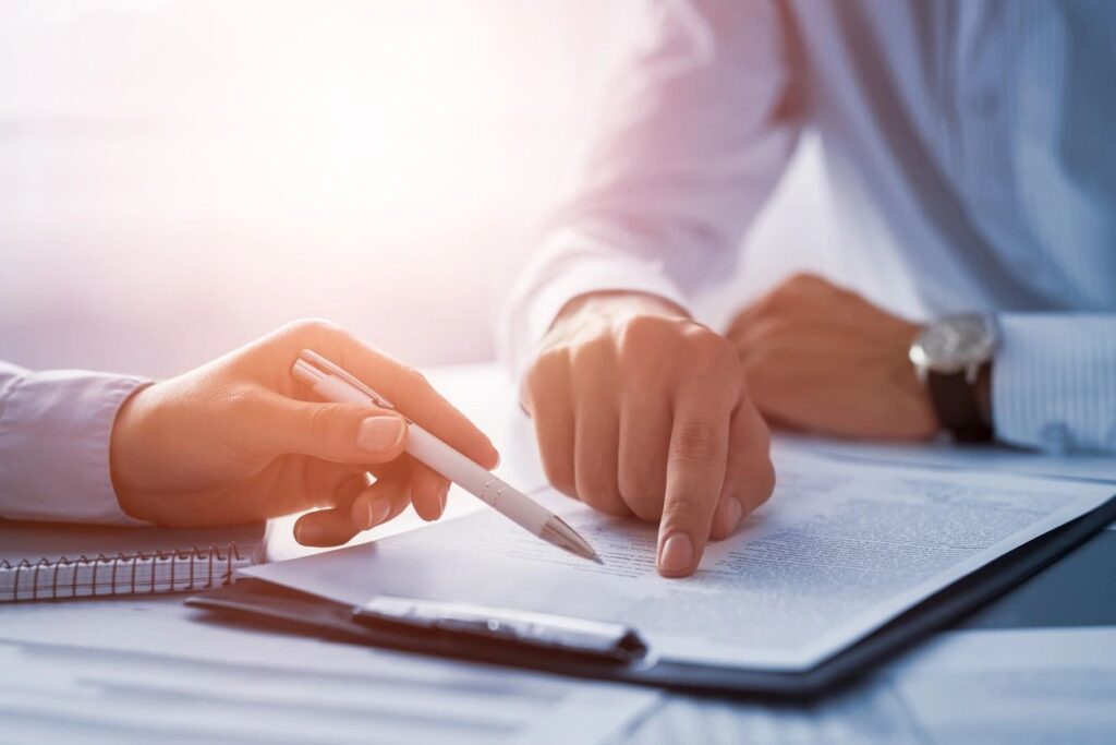 Two people reviewing contract with pen